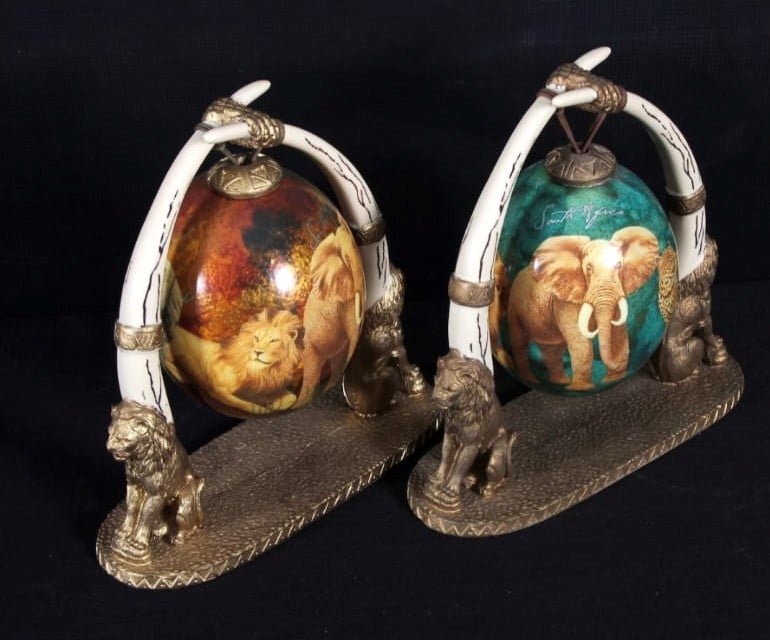 Two S.A. decoupage ostrich eggs on resin stand